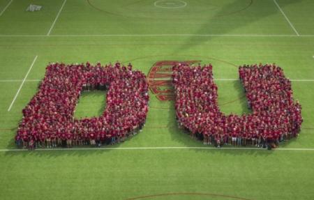 Student on a field forming the letters DU.